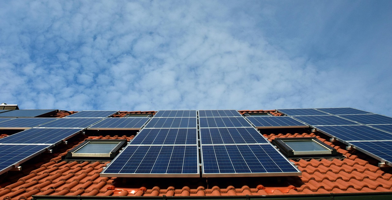 Solar panels Solar panels installed on a tiled rooftop under a partly cloudy sky.